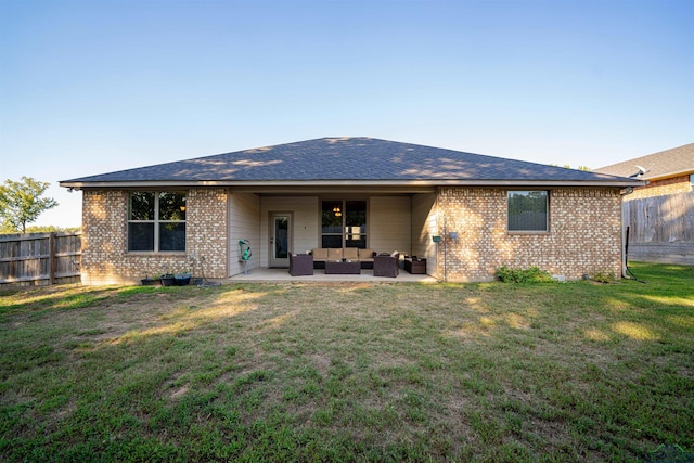 back of property with a lawn, an outdoor living space, and a patio area