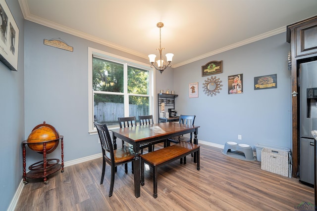 dining room with a chandelier, wood-type flooring, and crown molding