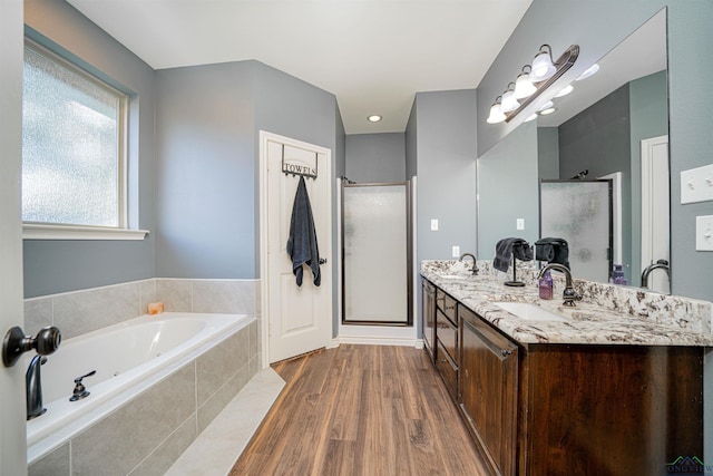 bathroom with hardwood / wood-style floors, vanity, and shower with separate bathtub