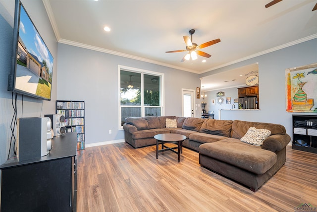 living room featuring wood-type flooring, ornamental molding, and a chandelier