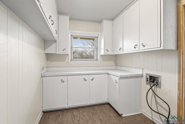 laundry area with dark wood finished floors, hookup for a washing machine, cabinet space, and baseboards