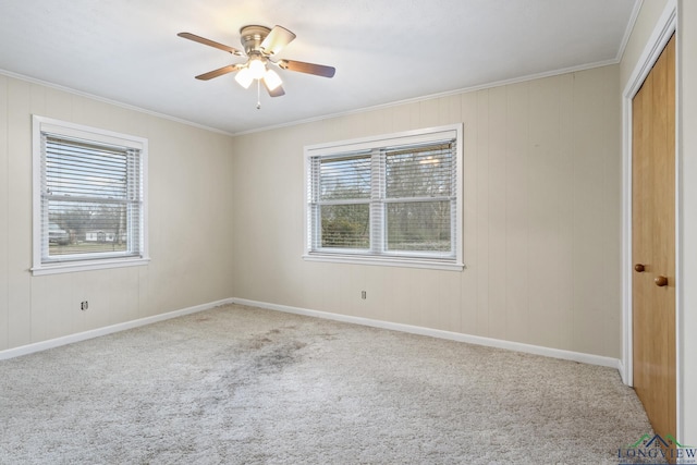 unfurnished bedroom featuring ceiling fan, a closet, baseboards, carpet floors, and ornamental molding