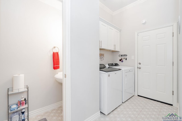 clothes washing area with crown molding, light floors, cabinet space, washing machine and dryer, and baseboards