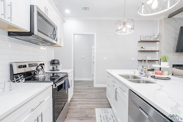 kitchen with stainless steel appliances, a sink, visible vents, ornamental molding, and backsplash