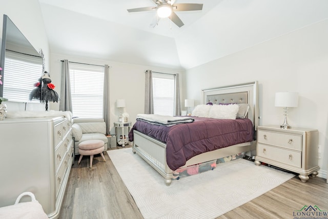 bedroom with a ceiling fan, light wood-type flooring, and vaulted ceiling