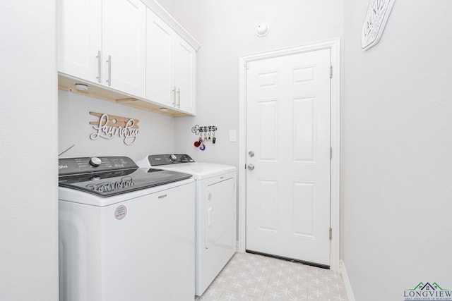 laundry area with baseboards, cabinet space, washer and clothes dryer, and light floors