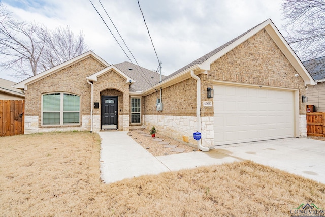 view of front of home featuring brick siding, roof with shingles, an attached garage, fence, and driveway