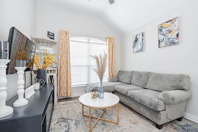 living room featuring lofted ceiling, baseboards, wood finished floors, and a healthy amount of sunlight