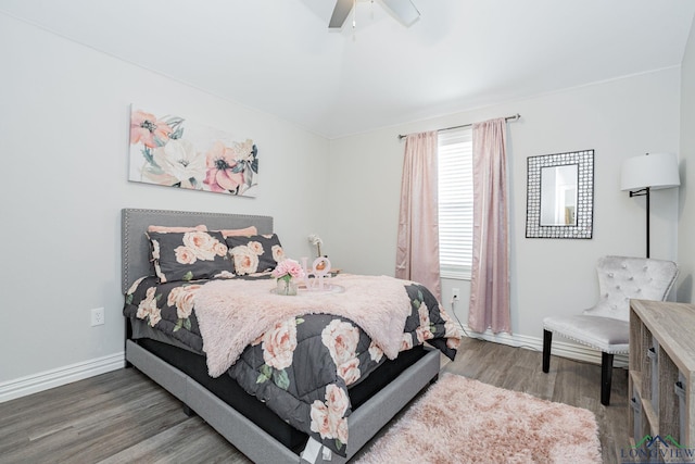 bedroom featuring a ceiling fan, vaulted ceiling, baseboards, and wood finished floors