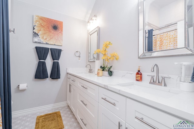 bathroom featuring double vanity, baseboards, a sink, and a shower with shower curtain