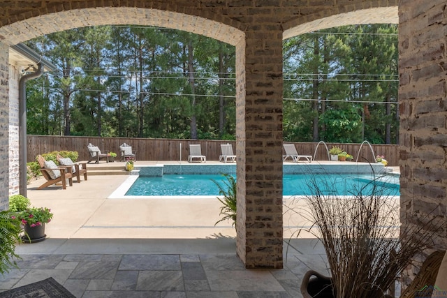 view of swimming pool with a fenced in pool, a fenced backyard, and a patio area