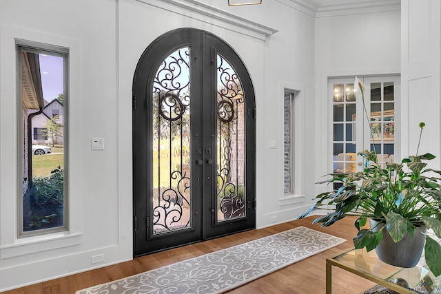 foyer entrance featuring arched walkways, a wealth of natural light, and french doors