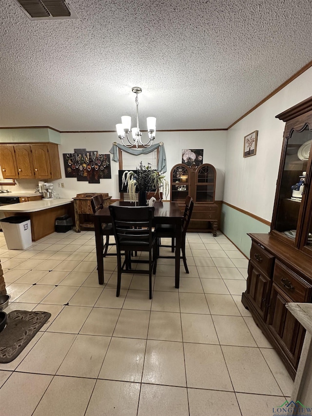 dining space with a chandelier, light tile patterned floors, a textured ceiling, and crown molding