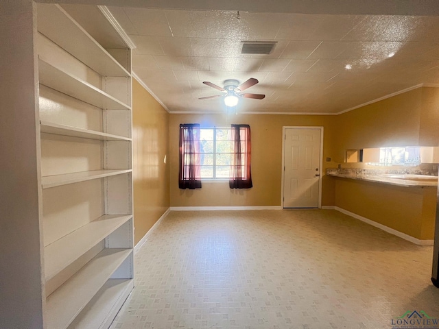 empty room featuring ceiling fan and ornamental molding