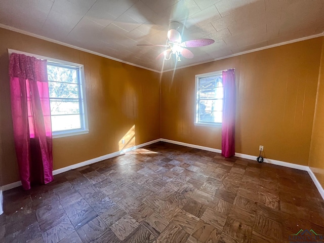 spare room featuring ceiling fan, crown molding, and a healthy amount of sunlight