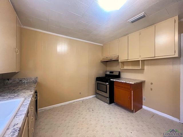 kitchen with cream cabinetry, sink, crown molding, and gas stove