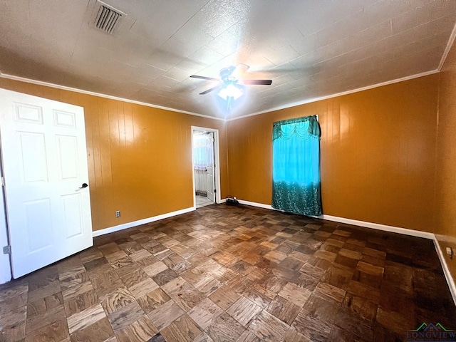 empty room featuring ceiling fan and ornamental molding