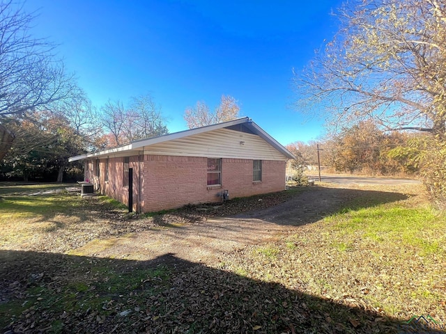 view of property exterior with cooling unit and a yard