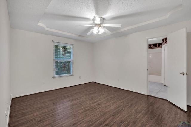 111 E Sycamore Ln, Longview, TX 75604 - unfurnished bedroom featuring a raised ceiling, wood finished floors, a textured ceiling, and ceiling fan