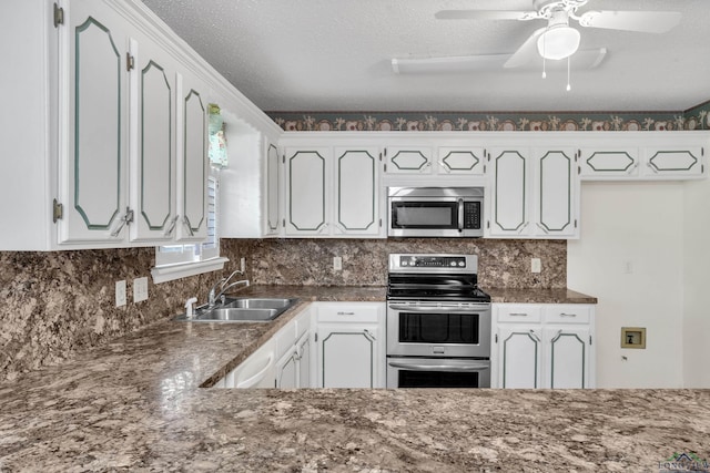 111 E Sycamore Ln, Longview, TX 75604 - kitchen featuring appliances with stainless steel finishes, white cabinets, backsplash, a textured ceiling, and ceiling fan