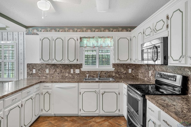 111 E Sycamore Ln, Longview, TX 75604 - kitchen featuring stainless steel appliances, a textured ceiling, decorative backsplash, dark countertops, and white cabinets