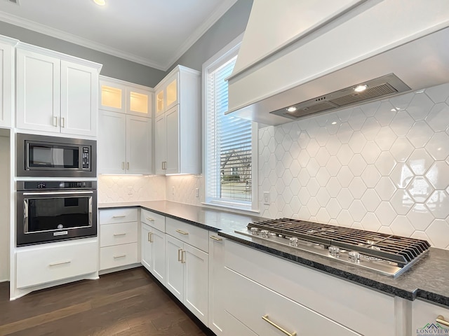 7323 Lake Pointe Cv, Tyler, TX 75703 - kitchen with ornamental molding, wall chimney range hood, dark wood-type flooring, white cabinetry, and stainless steel appliances