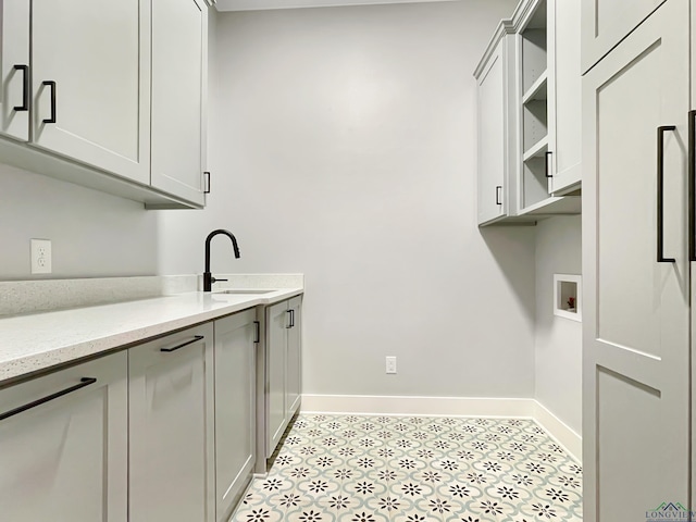 7323 Lake Pointe Cv, Tyler, TX 75703 - laundry area featuring baseboards, a sink, cabinet space, and washer hookup