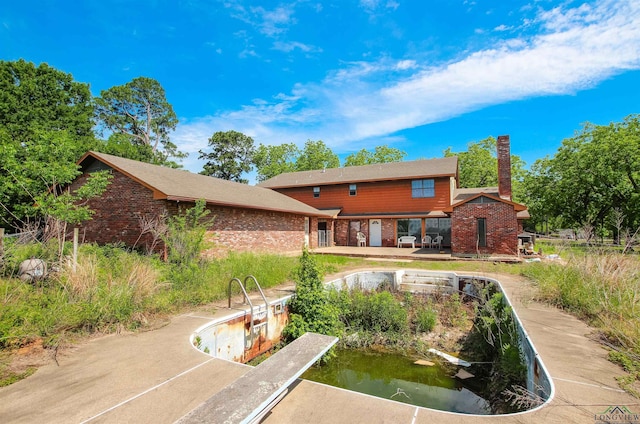 1006 Quitman St, Pittsburg, TX 75686 - rear view of property featuring brick siding and a chimney