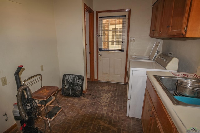 1006 Quitman St, Pittsburg, TX 75686 - laundry room featuring washer and dryer, cabinet space, brick patterned floors, and baseboards