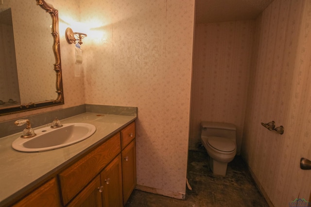 1006 Quitman St, Pittsburg, TX 75686 - bathroom with toilet, vanity, and wallpapered walls