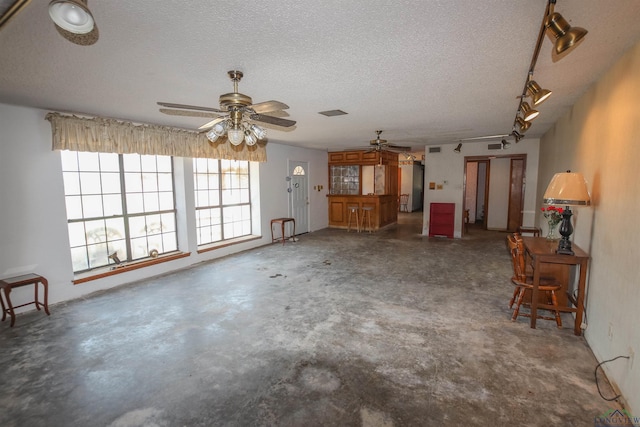 1006 Quitman St, Pittsburg, TX 75686 - unfurnished living room featuring ceiling fan, concrete flooring, and a textured ceiling
