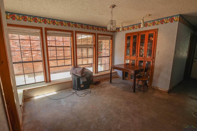 1006 Quitman St, Pittsburg, TX 75686 - dining space with a textured ceiling, plenty of natural light, a chandelier, and a wood stove