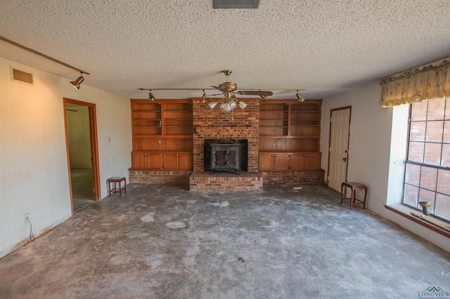1006 Quitman St, Pittsburg, TX 75686 - unfurnished living room with ceiling fan, track lighting, a textured ceiling, built in shelves, and a fireplace