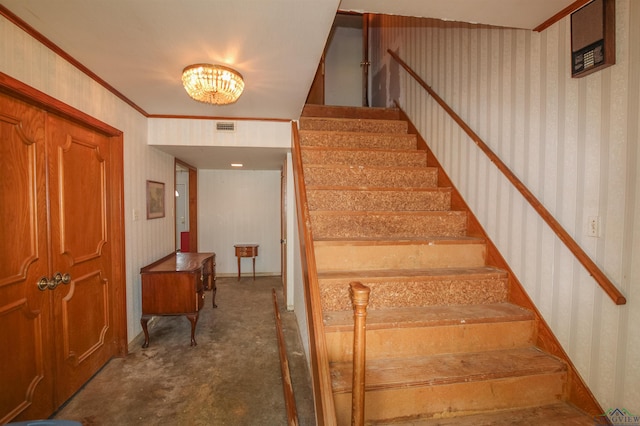 1006 Quitman St, Pittsburg, TX 75686 - staircase with wallpapered walls and a chandelier