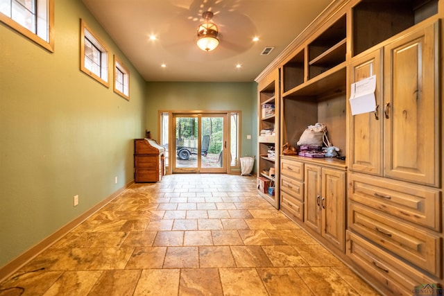 mudroom with built in shelves and ceiling fan