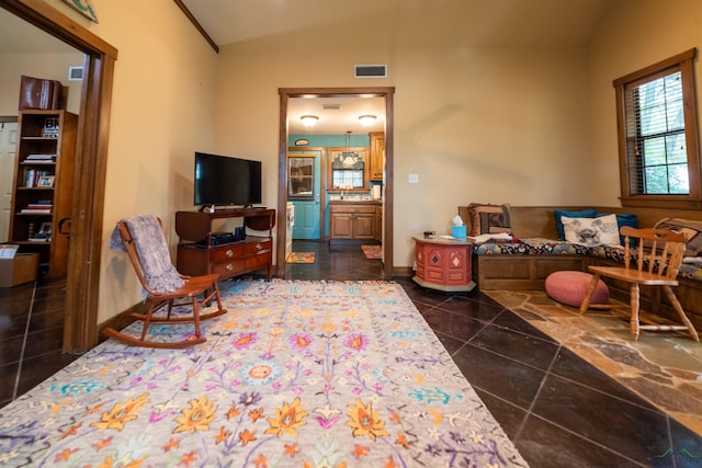 living room with dark tile patterned flooring and vaulted ceiling