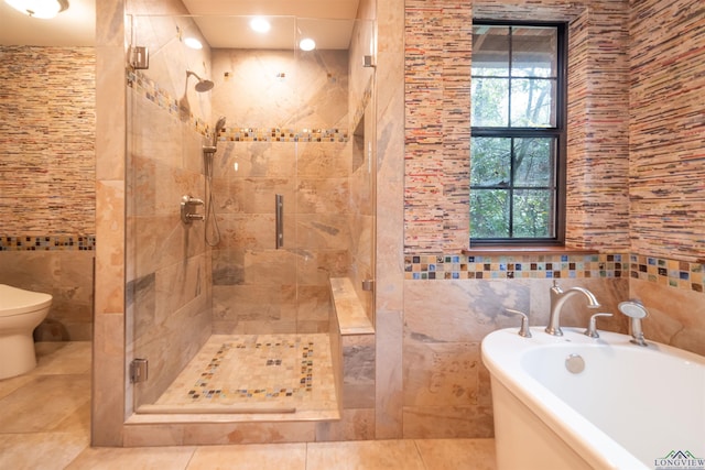 bathroom featuring tile patterned flooring, toilet, tile walls, and plus walk in shower