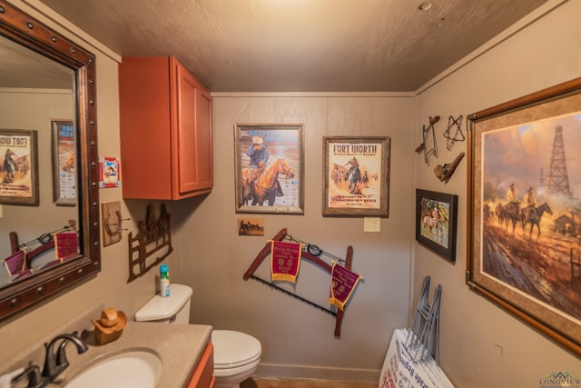 bathroom featuring vanity, ornamental molding, and toilet