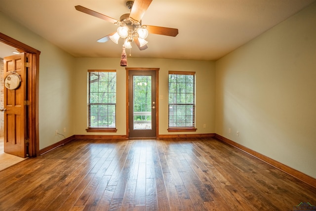 spare room with dark hardwood / wood-style flooring and ceiling fan