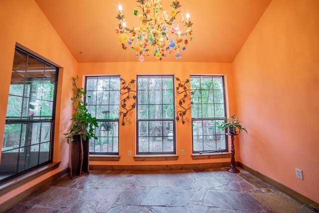 doorway featuring an inviting chandelier, plenty of natural light, and lofted ceiling