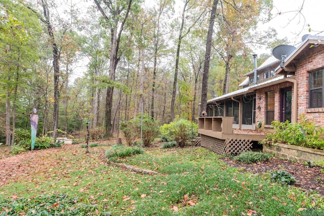 view of yard with a deck and a sunroom