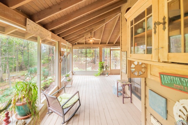 sunroom / solarium with lofted ceiling with beams, ceiling fan, and wood ceiling