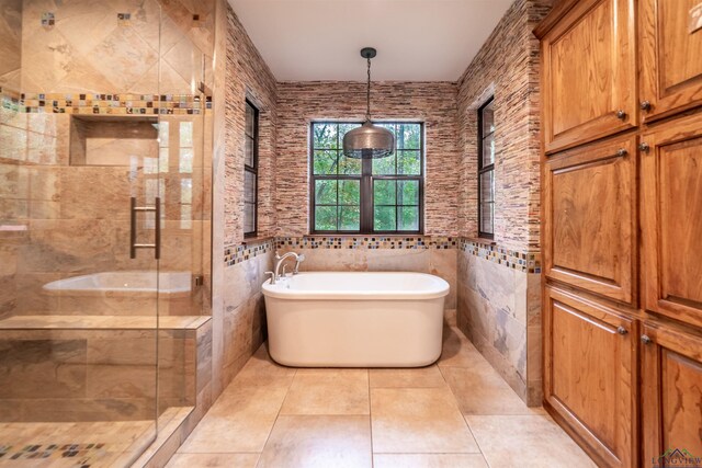 bathroom featuring tile patterned floors, independent shower and bath, and tile walls