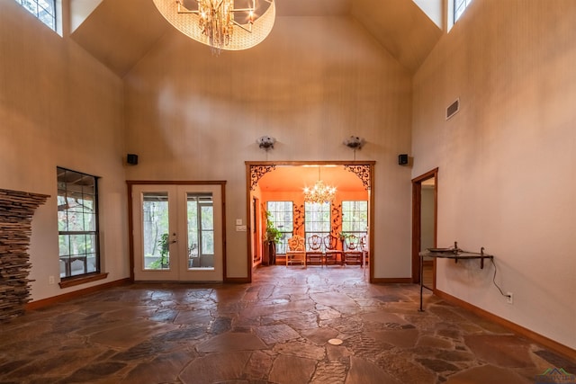 entryway featuring french doors, a high ceiling, and an inviting chandelier