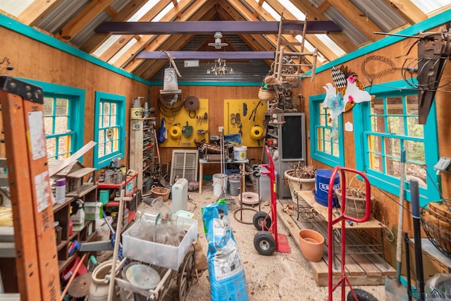 misc room with vaulted ceiling with beams, a workshop area, and wood walls