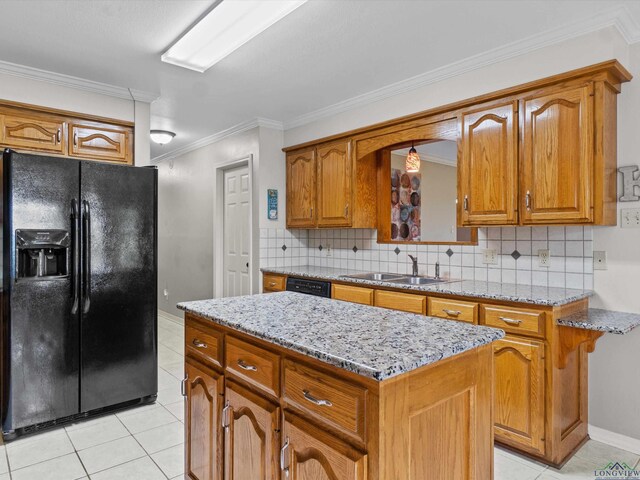 kitchen featuring black appliances, brown cabinets, light tile patterned flooring, and a sink