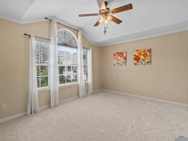 carpeted empty room featuring a ceiling fan, crown molding, vaulted ceiling, and baseboards