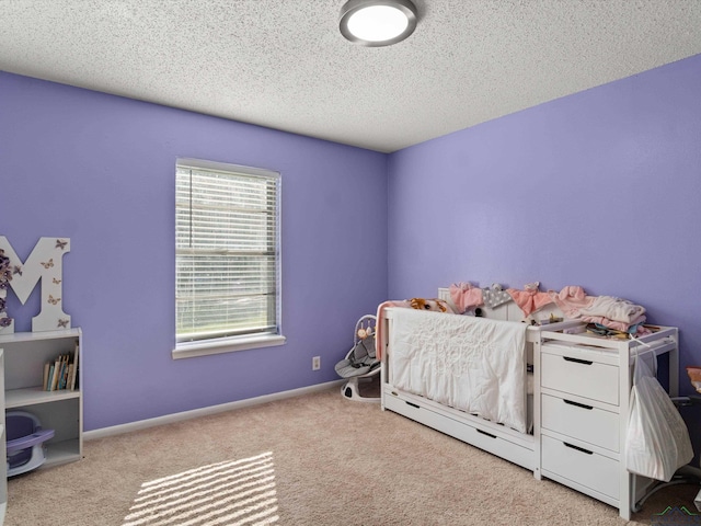 bedroom featuring light carpet and a textured ceiling