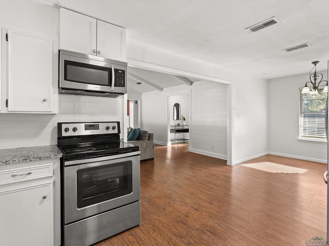 kitchen with white cabinets, backsplash, stainless steel appliances, and an inviting chandelier