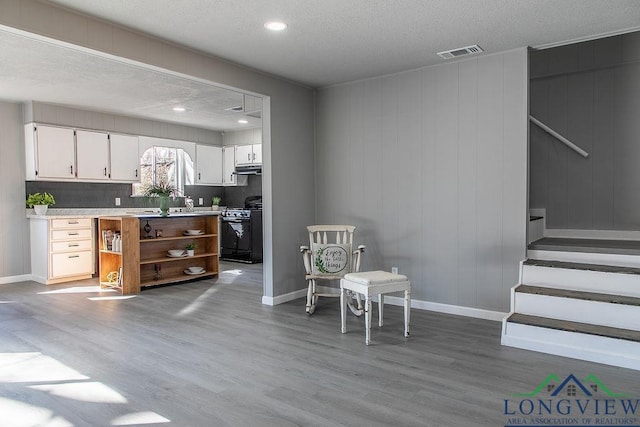 living area with a textured ceiling and hardwood / wood-style flooring